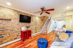 a living room with a brick wall and a ceiling fan at The Trailblazing Tribble House of Federal Hill in Baltimore