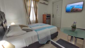 Dormitorio pequeño con cama y mesa en BELLA SUITE frente al Aeropuerto en Catia La Mar