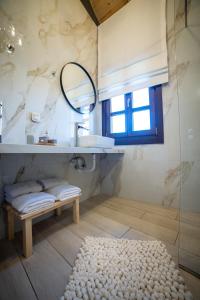 a bathroom with a sink and a mirror and a rug at Casacaldametsovo in Metsovo
