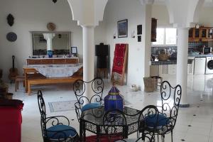 een kamer met een tafel en stoelen en een keuken bij Riyad Azul entre nature et océan in Sidi Kaouki