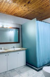 een badkamer met een toilet, een wastafel en een spiegel bij Nadia's Beach House in Pefkari