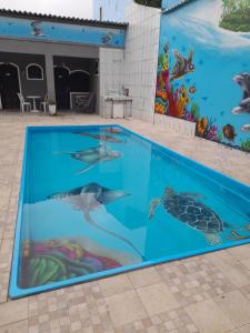 uma piscina com um mural de golfinhos e tartarugas em Pousada Flora Búzios em Búzios