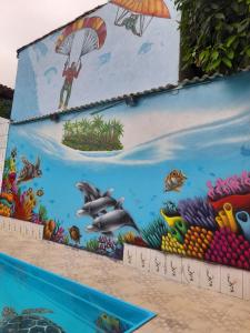 um mural do oceano no lado de um edifício em Pousada Flora Búzios em Búzios