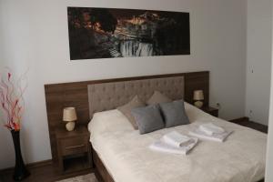 a bedroom with a bed with two towels on it at Royal City Apartments in Jajce