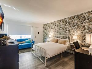 um quarto com uma cama e um sofá azul em Deco Bungalow 1block from beach with parking em Miami Beach