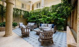 een patio met stoelen, tafels en planten bij Hotel Casa Canabal by Faranda Boutique in Cartagena