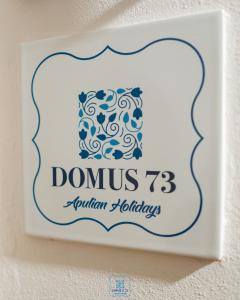 een bord op een muur waarop staat domus return holidays bij DOMUS 73 Apulian holidays in Barletta