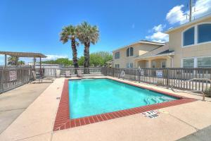 a swimming pool in front of a house at Palm Tree Paradise in Padre Island