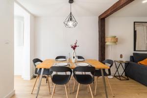 uma sala de jantar com uma mesa de madeira e cadeiras em Apartamento de diseño en el corazón de Santander em Santander