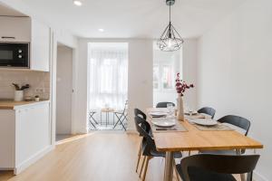 a dining room and kitchen with a wooden table and chairs at Apartamento de diseño en el corazón de Santander in Santander