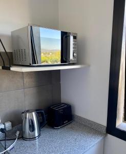a microwave sitting on a shelf in a kitchen at Departamento Cordillera II in Godoy Cruz