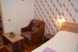 a bedroom with a bed and a chair and a lamp at Apartament Supercentral Sibiu in Sibiu +13 photos