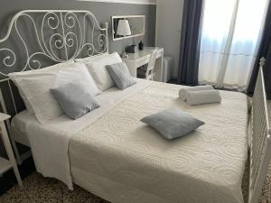 um quarto com uma cama grande com duas almofadas em Casa Verga em Siracusa