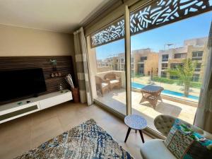 a living room with a tv and a large window at Mangroovy Seafront condo - Great Kite Surfing in Hurghada
