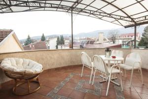 a patio with a table and chairs on a balcony at Central Exclusive Apartment/Penthouse in Bitola