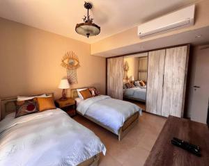 um quarto com 2 camas e um lustre em Mangroovy Seafront condo - Great Kite Surfing em Hurghada