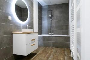 a bathroom with a white sink and a shower at Coeur de Ville à partager in Montbéliard