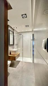 y baño con ducha, lavabo y bañera. en Uroczy apartament - Sopot en Sopot