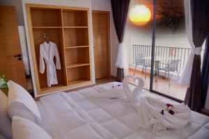 Un dormitorio con una gran cama blanca con una bata. en Hotel beaux arts en Meknès
