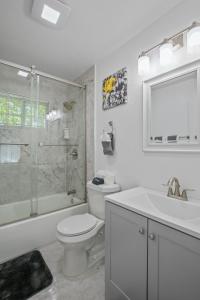 a bathroom with a toilet and a shower and a sink at Four Bedroom Home Near Hartsfield Jackson Airport in Riverdale