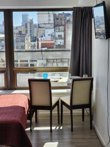 Habitación con mesa, 2 sillas y ventana en Infinit Point Apartment en Buenos Aires