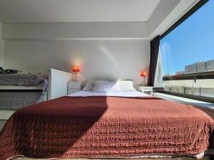 1 dormitorio con 1 cama grande y ventana grande en Infinit Point Apartment en Buenos Aires