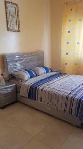 烏季達的住宿－Apart salma，一间卧室配有一张带蓝色棉被的床