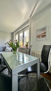 sala de estar con mesa de cristal y 2 sillas en Uroczy apartament - Sopot en Sopot