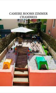 einen Kinderspielplatz mit einem Tisch und einem Sonnenschirm in der Unterkunft Pink House Garden in Monterosso al Mare