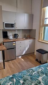 uma cozinha com armários brancos e uma bancada em Randwick City Lodge 2 em Sydney