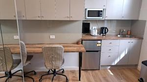 a kitchen with a counter with chairs and a microwave at Randwick City Lodge 2 in Sydney