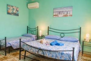 two beds in a room with blue walls at Appartamenti Celestina Portoferraio in Portoferraio