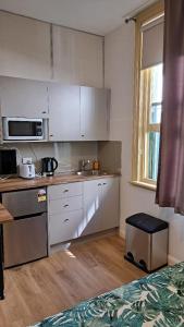 een keuken met witte kasten en een aanrecht bij Randwick City Lodge 2 in Sydney