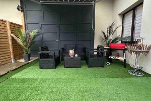 a patio with green grass and chairs and a garage at Villa Spacieuse SPA Sauna Billiard Netflix in Strasbourg