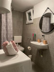 a bathroom with a sink and a basket of towels at KN House with two apartments near sea in Rogoznica