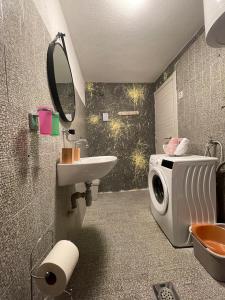 uma casa de banho com uma máquina de lavar roupa e um lavatório em KN House with two apartments near sea em Rogoznica