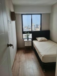 um pequeno quarto com uma cama e uma janela em Massimo Apartament em Lima