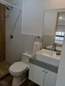 a white bathroom with a toilet and a sink at Massimo Apartament in Lima