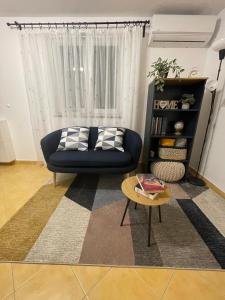 uma sala de estar com um sofá azul e uma mesa em KN House with two apartments near sea em Rogoznica