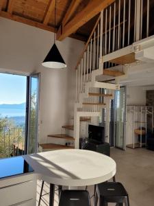 ein Esszimmer mit einem Tisch, Stühlen und einer Treppe in der Unterkunft Casolare Cento Ulivi Luxury & Charme in Ascea
