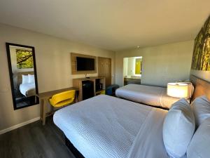 a hotel room with two beds and a television at Days Inn by Wyndham Emporia in Emporia