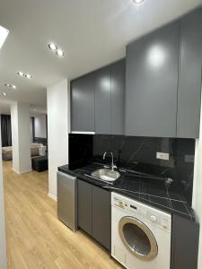 a kitchen with a washing machine and a sink at CozyStayApartments by Flow in Tirana