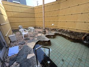 a small pond with a white chair in a yard at Monbetsu Prince Hotel in Mombetsu