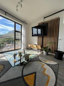 uma sala de estar com uma mesa de vidro e uma grande janela em Stunning Modern apartment Cape Town City Centre. em Cidade do Cabo