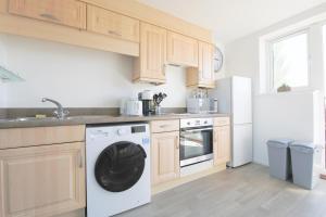 a kitchen with a washing machine and a refrigerator at StayRight 2Bed Apartment Overlooking Water with Free parking and 2 Bathrooms in Cardiff