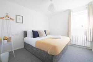 a white bedroom with a bed and a window at StayRight 2Bed Apartment Overlooking Water with Free parking and 2 Bathrooms in Cardiff