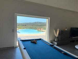 einen Billardtisch in einem Zimmer mit einem großen Fenster in der Unterkunft Casa Lagone - Villa Luxe avec Piscine et Superbe Vue in Cargèse