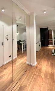 salon ze szklanymi ścianami i drewnianą podłogą w obiekcie LUMI Apartament Mokotów w Warszawie