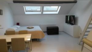 a bedroom with two beds and a tv and a table at Aparthotel Midi Residence in Brussels