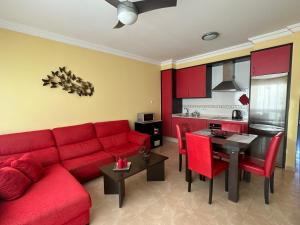 a living room with a red couch and a table at Aguarii Cotillo in El Cotillo